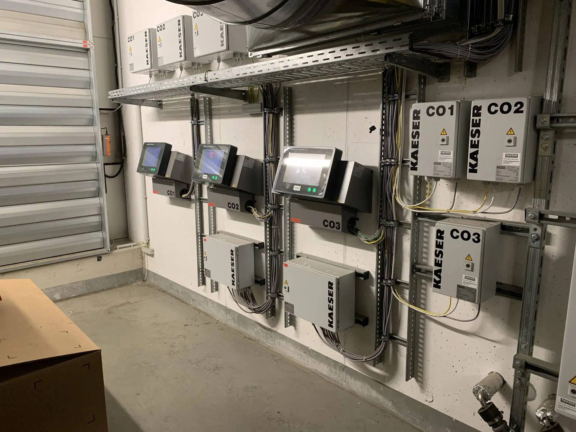 Energieoptimierung Druckluftanlagen Wandinstallation mit Steuerungseinheiten und Kaeser-Modulen