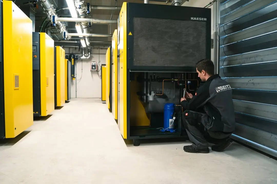 24-Stunden-Service Techniker bei Wartung eines Kaeser-Kompressors im Technikraum