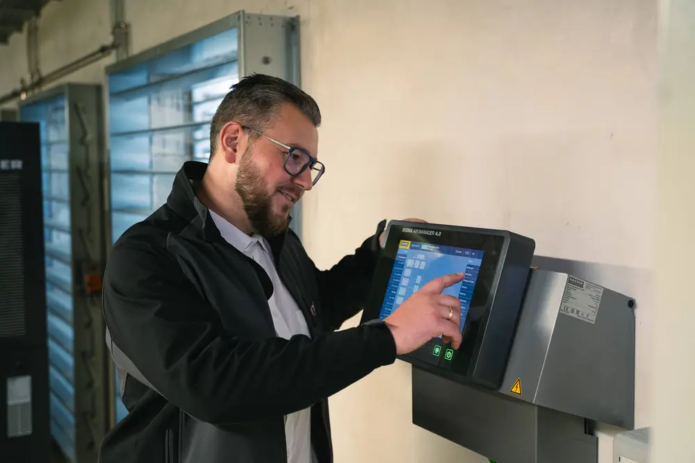 Mitarbeiter bedient Steuerungseinheit mit Touchscreen